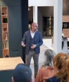 Un uomo parla davanti a un gruppo in una cucina moderna di Nolte Kitchen.