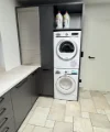 Locale lavanderia con lavatrice e asciugatrice in armadi moderni di Nolte.