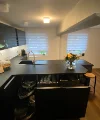 Cucina moderna con armadi scuri e isola, arredata da Nolte Kitchen.