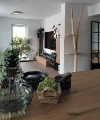 Un elegante soggiorno con mobili moderni e piante, presentato da Nolte Living.