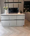 Cucina moderna con isola e vasi di fiori, design di Nolte Kitchen.
