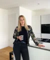 Una donna in una cucina moderna con armadi bianchi, Nolte Kitchen.