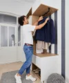 Una persona appende una giacca in un moderno ingresso progettato da Nolte Living.