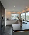 Cucina moderna con piani neri e grandi finestre, design di Nolte Kitchen.