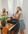 Una donna asciuga i capelli in un elegante bagno con mobili neri. Nolte SPA.