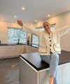Una donna è seduta in una cucina moderna con design Nolte.