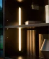 Une étagère élégante avec éclairage et boîtes décoratives.
