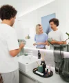 A couple folding towels in a modern bathroom, mirror in the background, Nolte SPA.