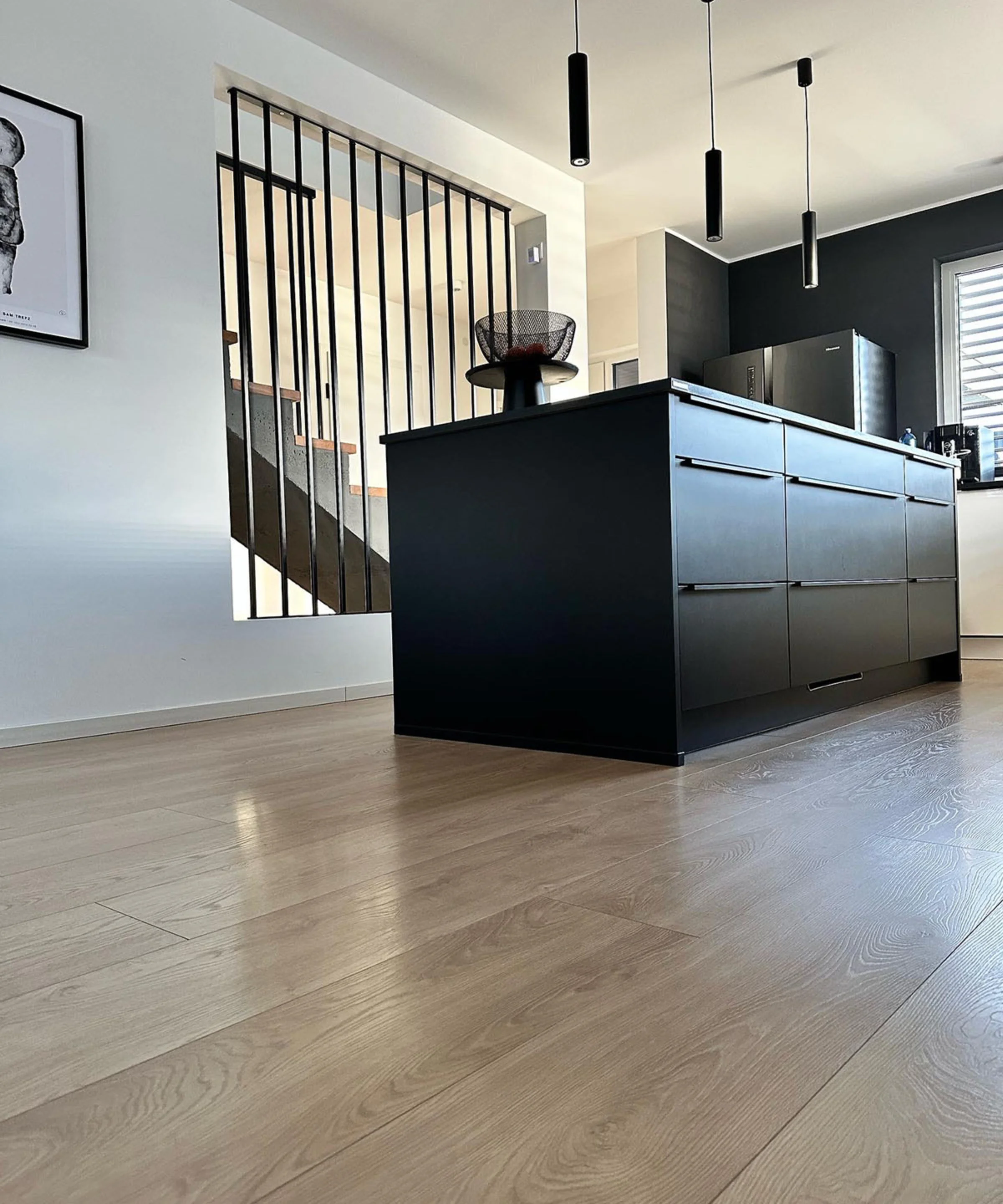 Moderne Küche mit schwarzer Insel und Pendelleuchten, von Nolte Kitchen.