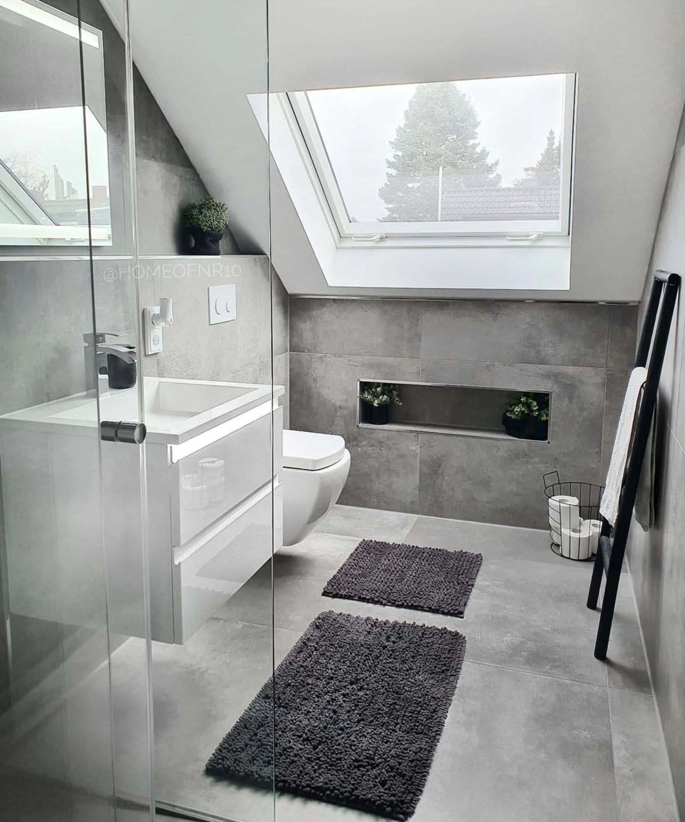 Bagno moderno con piastrelle grigie, lucernario e arredamento minimalista. Nolte SPA.