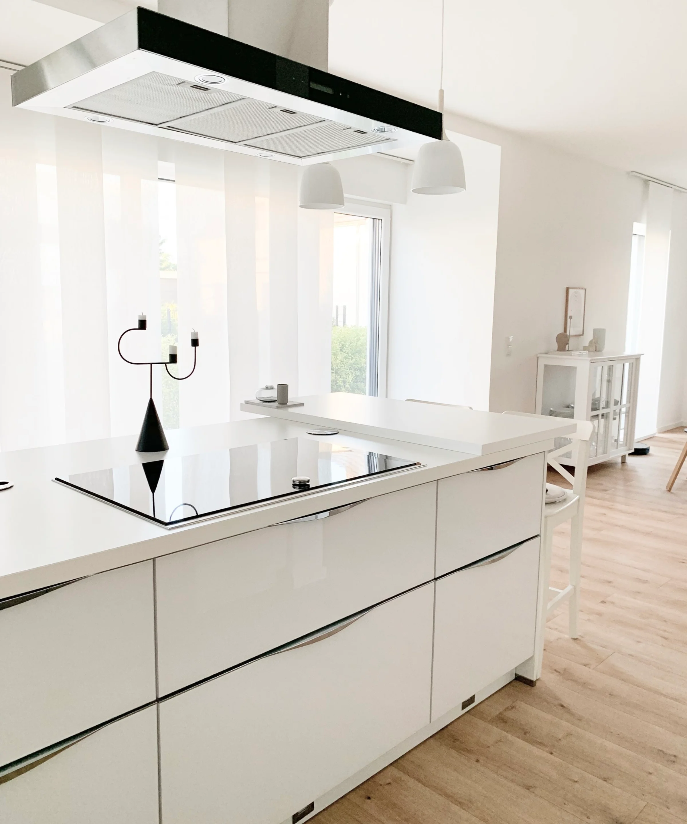 Cucina moderna con isola bianca e cappa aspirante, design di Nolte Kitchen.