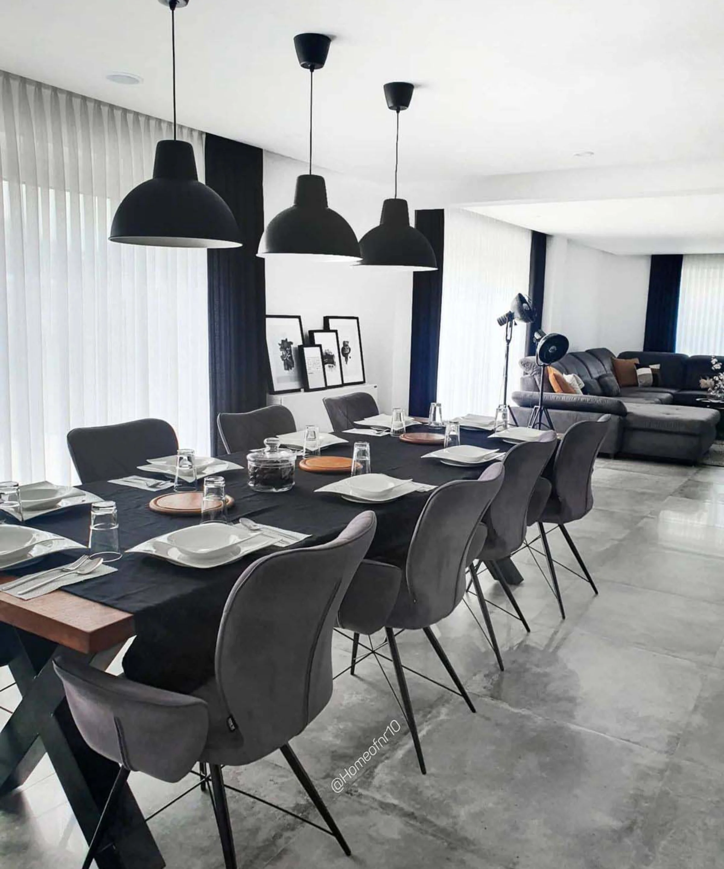 Sala da pranzo elegante con tavolo lungo e lampade moderne di Nolte Living.