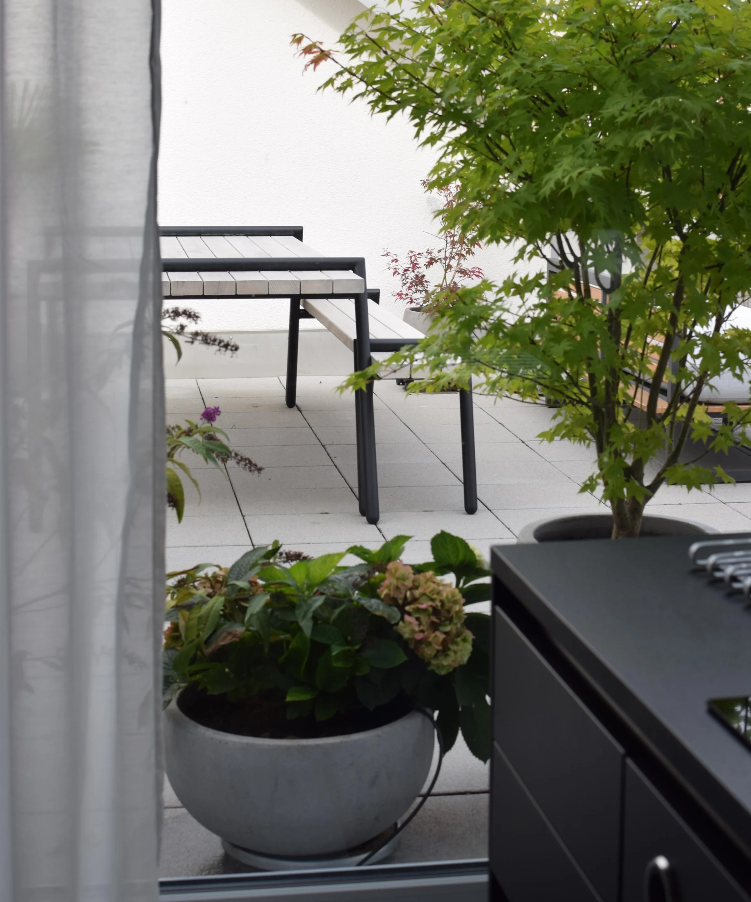 Una terrazza moderna con piante e mobili da esterno.