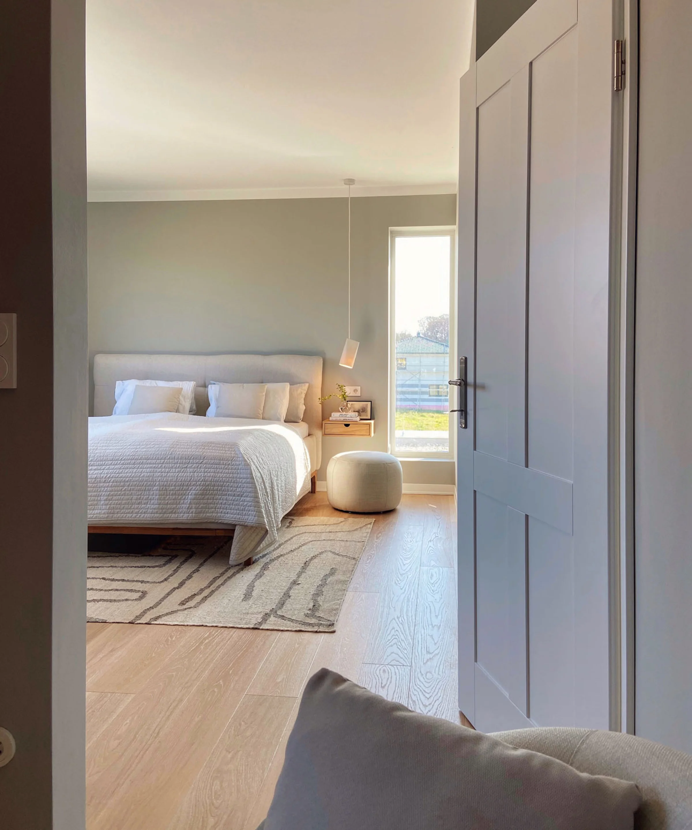 Camera da letto moderna con letto matrimoniale e tappeto, vista attraverso una porta aperta. Nolte Living.