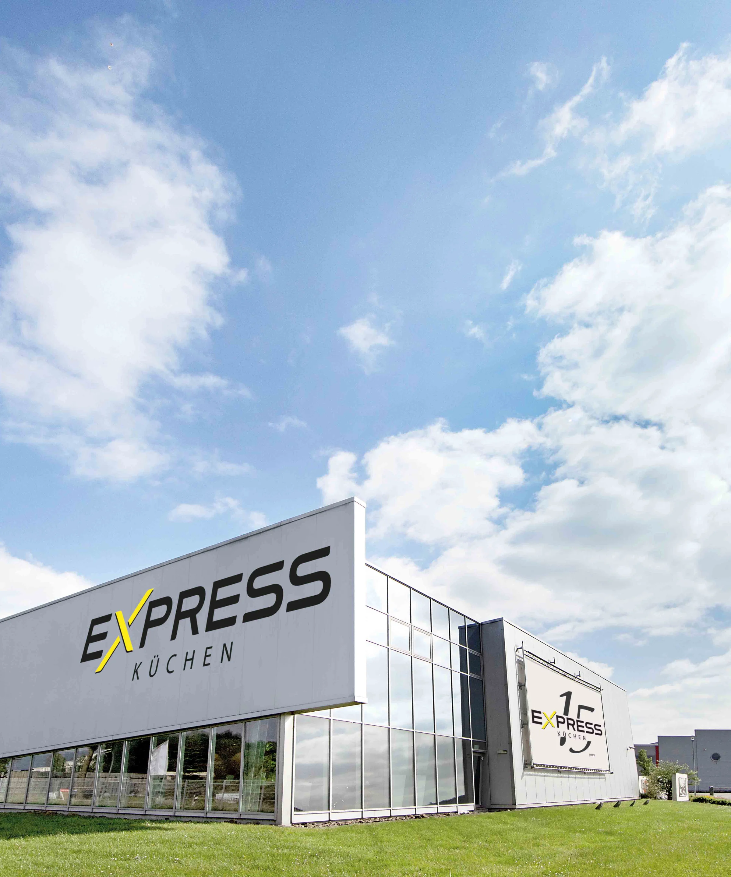Das Gebäude von Express Küchen steht unter einem blauen Himmel mit Wolken.