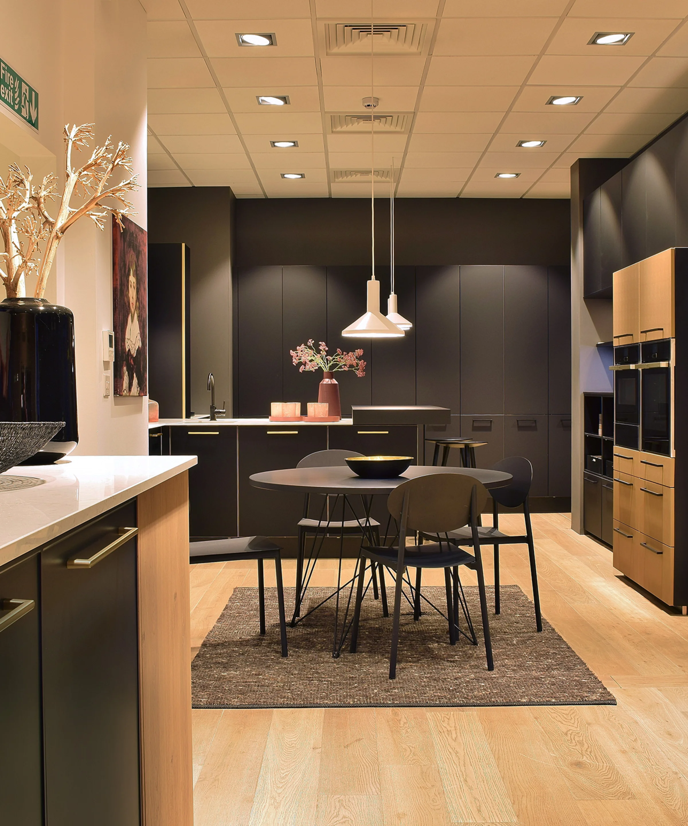 Cucina moderna con tavolo da pranzo e illuminazione di Nolte Kitchen.