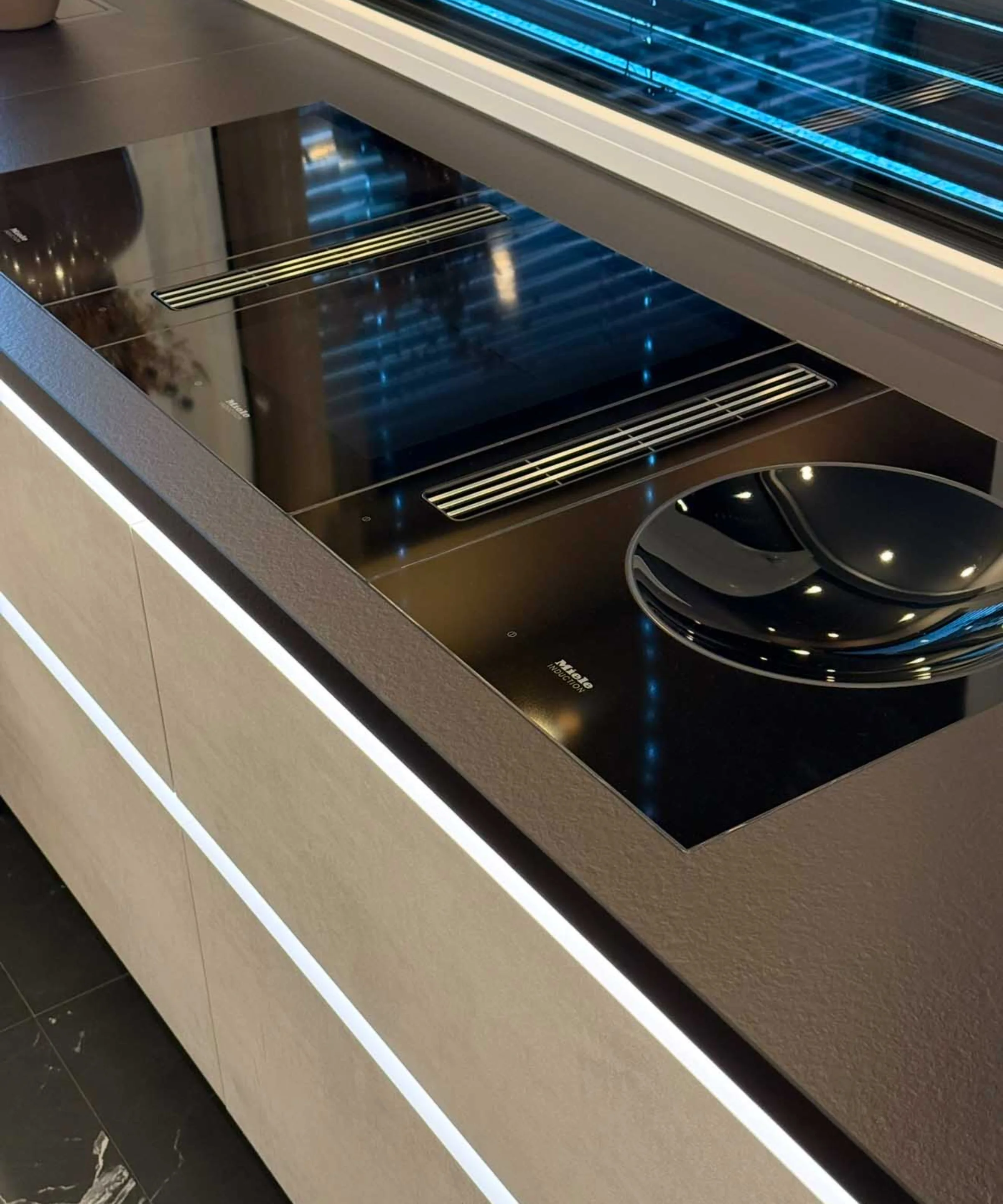 Cucina moderna con piano cottura nero e superfici eleganti di Nolte Kitchen.