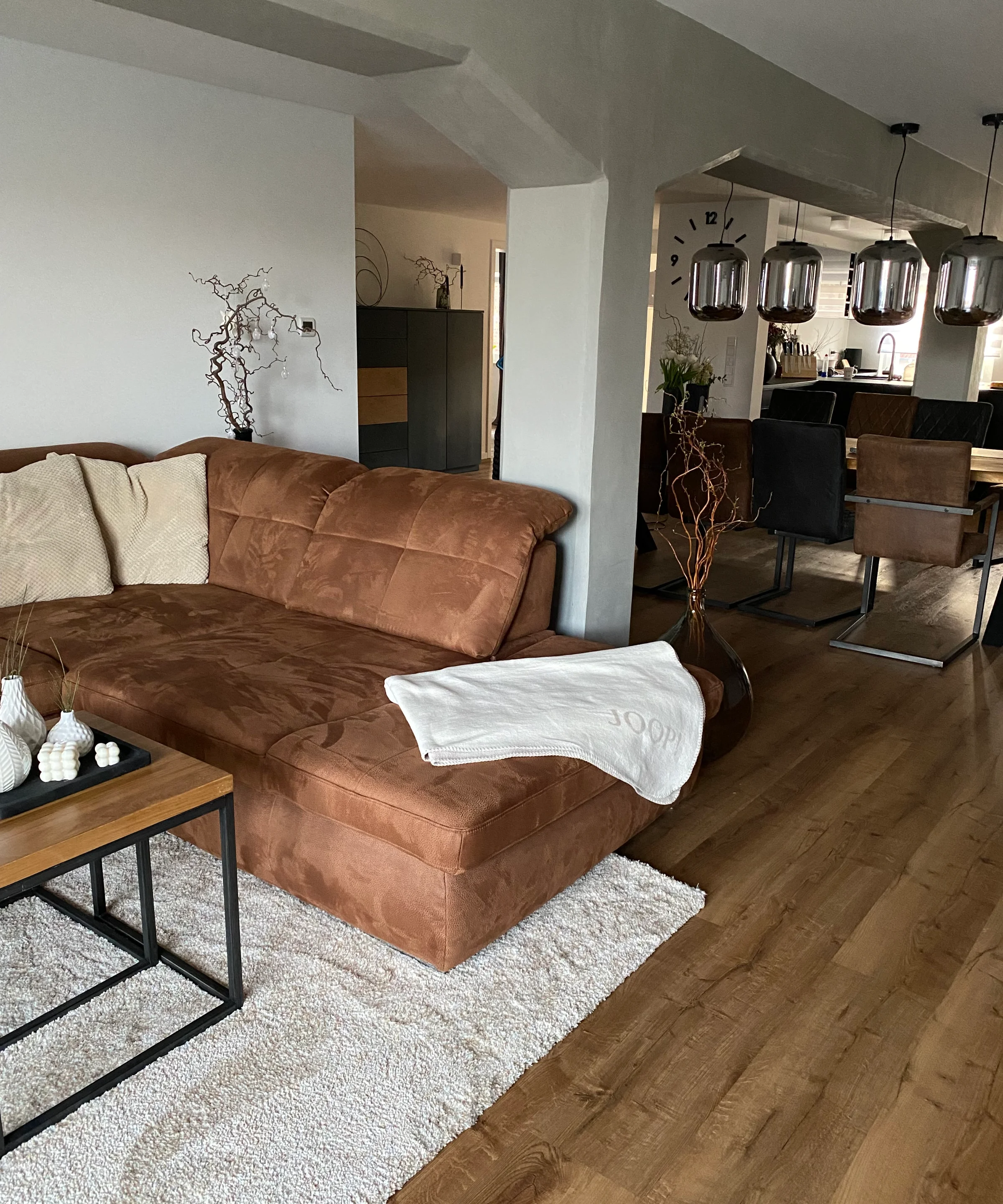 Soggiorno moderno con divano marrone e zona pranzo; Nolte Living.
