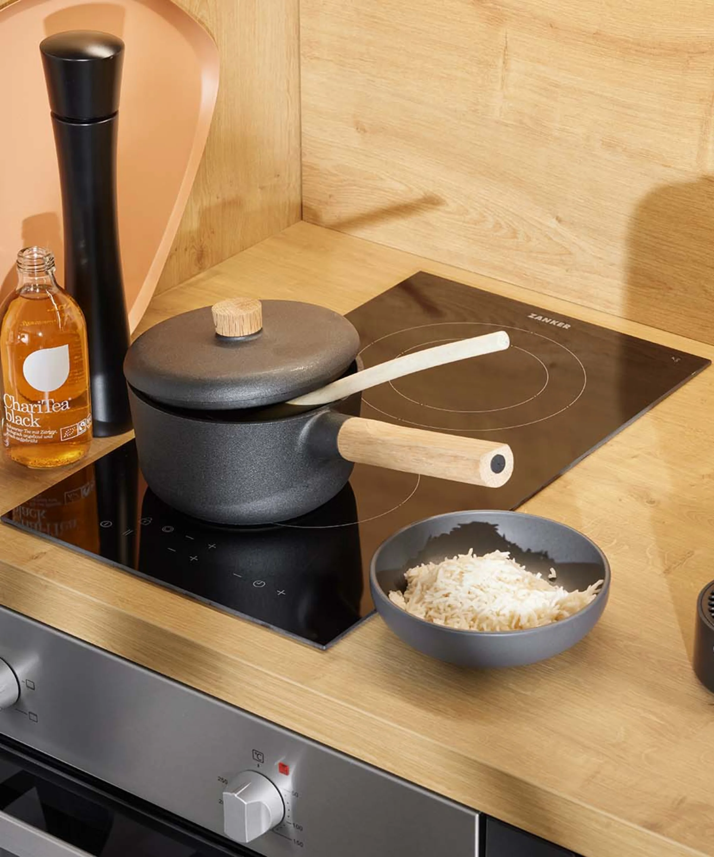 In una cucina moderna con dettagli in legno c'è un fornello con pentola e ciotola di riso. Nolte Kitchen.