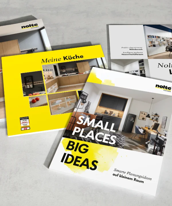 Quattro brochure su Nolte Kitchen, Nolte Living e NolteNeo design sono su un tavolo.
