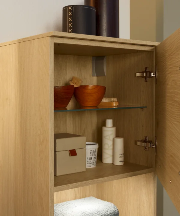 Un armadietto da bagno aperto con prodotti per la cura e asciugamani, Nolte SPA.