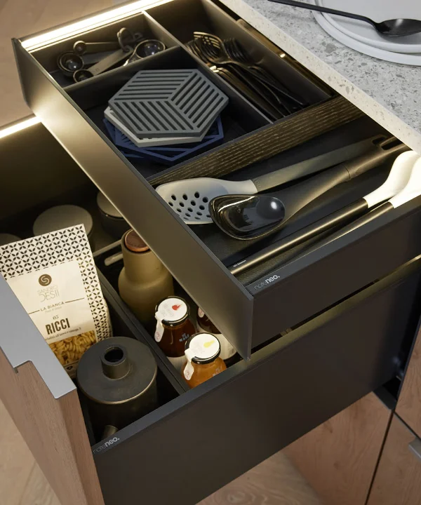 Un cassetto da cucina aperto con posate e spezie in un ambiente moderno di cucina Nolte.