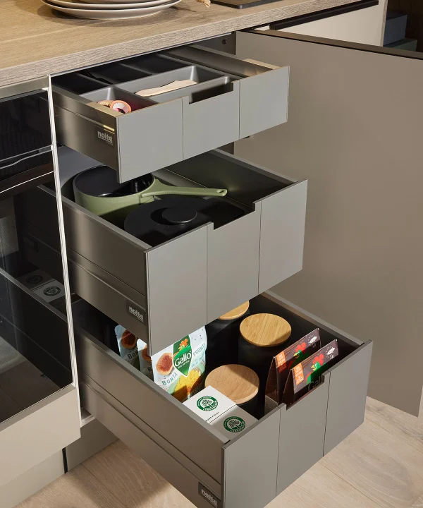 Cassetti della cucina aperti con utensili e spezie in un ambiente moderno di cucina Nolte.