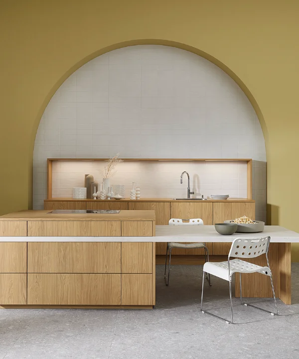 Cucina moderna con frontali in legno e isola davanti a parete verde oliva, Nolte Kitchen.