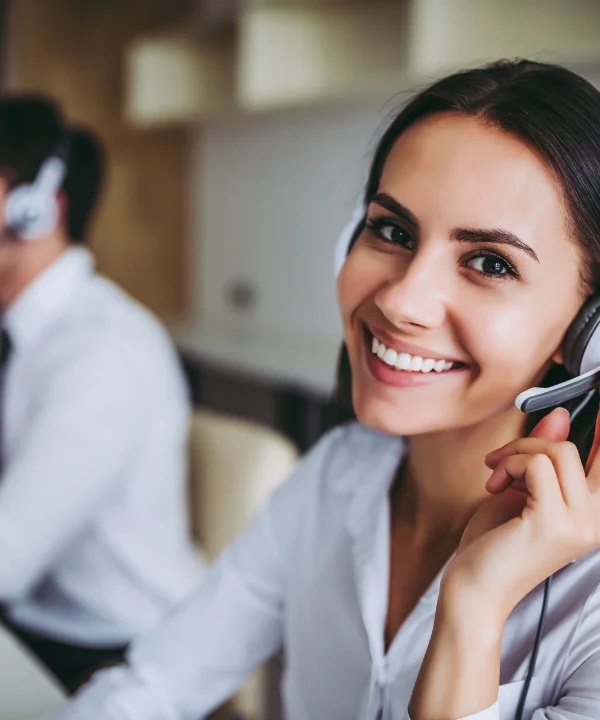 Due persone lavorano in un ufficio moderno con cuffie.
